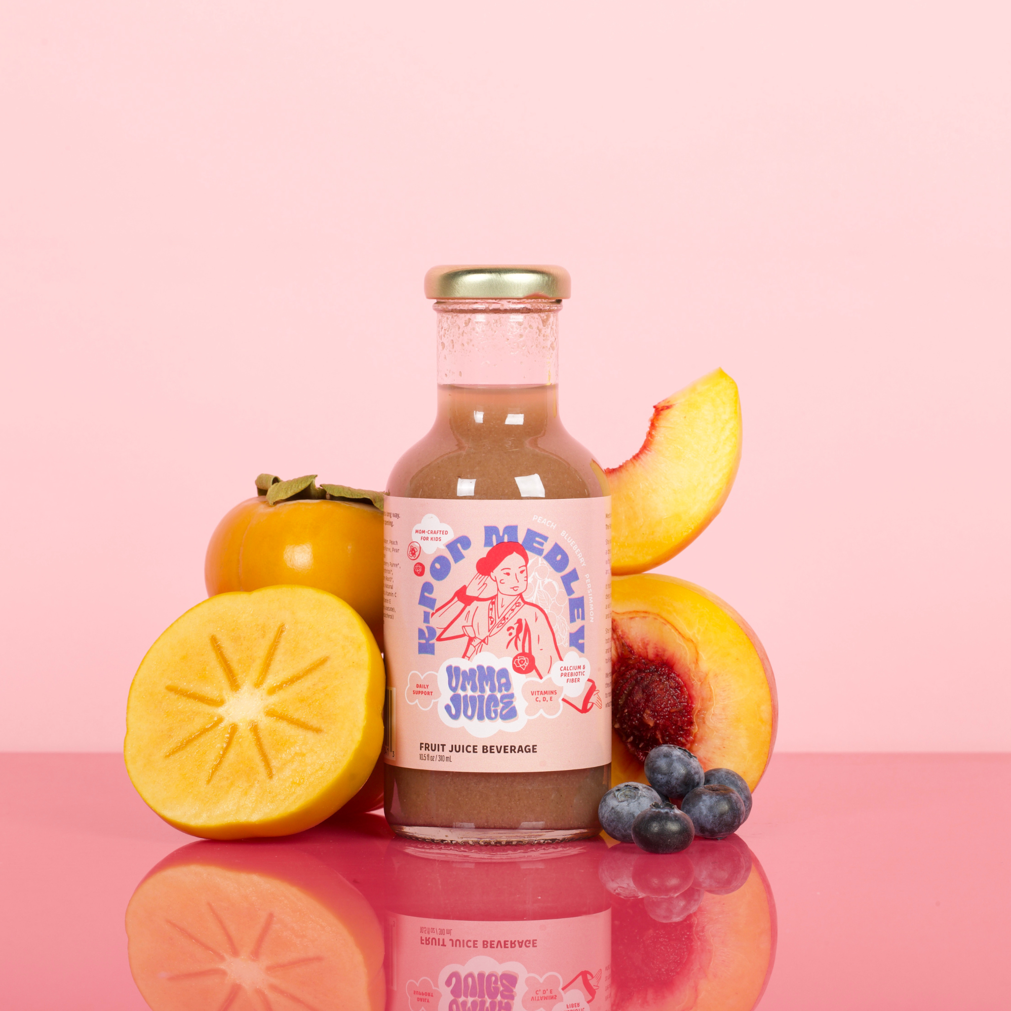 Bottle of 'K-Pop Medley' juice with persimmon, peach, and blueberry on a pink background
